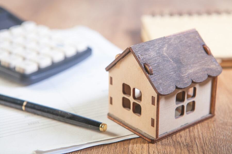Model house with a calculator and pen