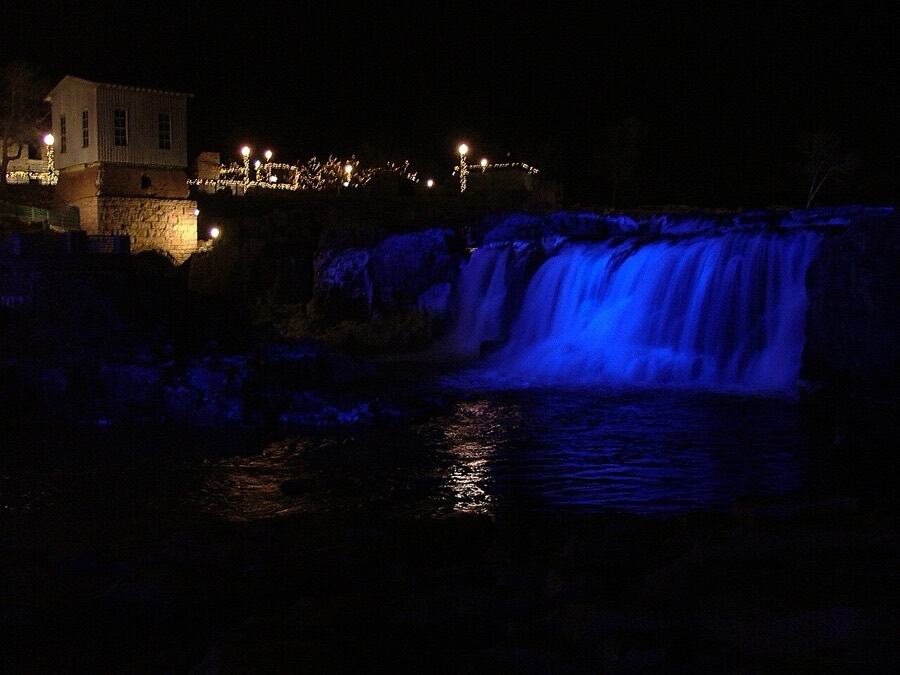 Falls Park at night with the falls lit blue for the holidays